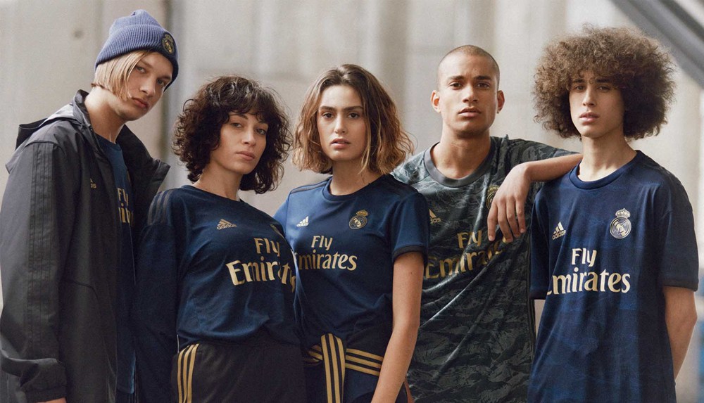 Giovani tifosi con maglia Real Madrid Away blu, esempio di stile casual per l’uso quotidiano.